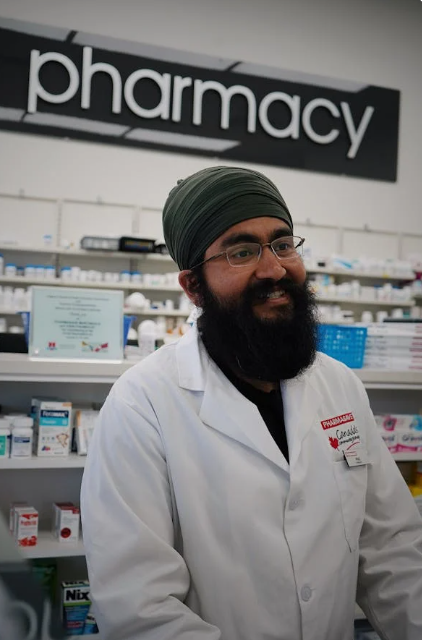 A professional pharmacist in a white lab coat explaining proper medication dosage to a patient in a modern pharmacy